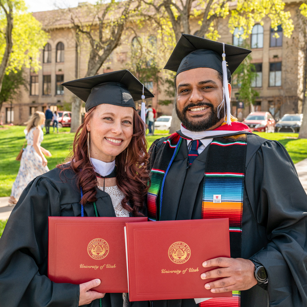 two new grads posed side by side with their congradulatory documents